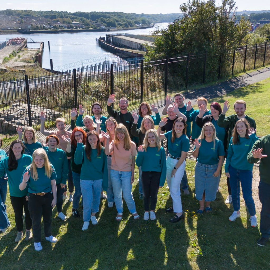 A group of Rise staff together, waving to the camera