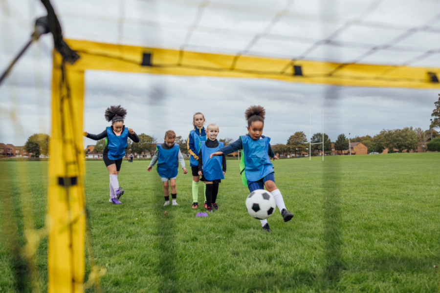 Girl shooting football at goal